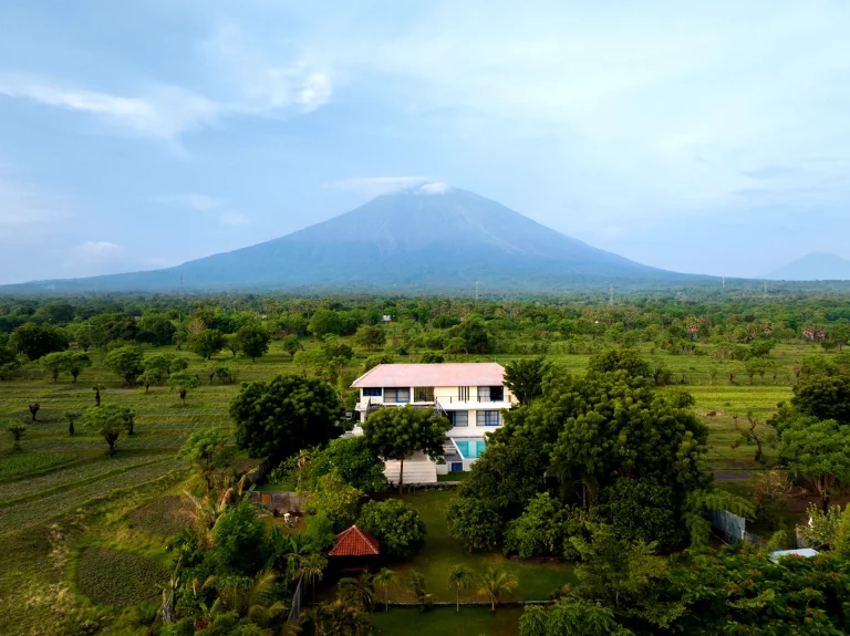 Aerial view of a modern villa in Tulamben, Bali, with a private pool and panoramic backdrop of Mount Agung